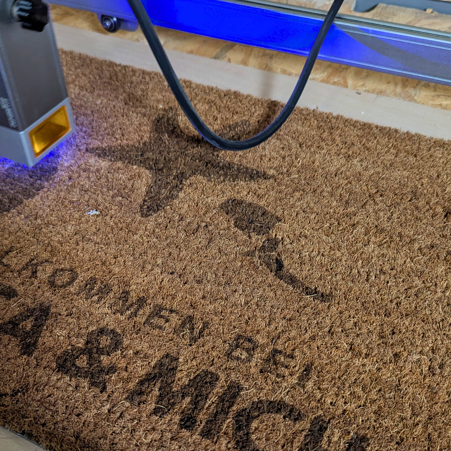 Ein Bild auf dem gezeigt wird wie mit einem Laser eine Fußmatte personalisiert wird