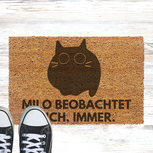 Personalisierte Kokos Fußmatte - "Katzenname" beobachtet dich. Immer.